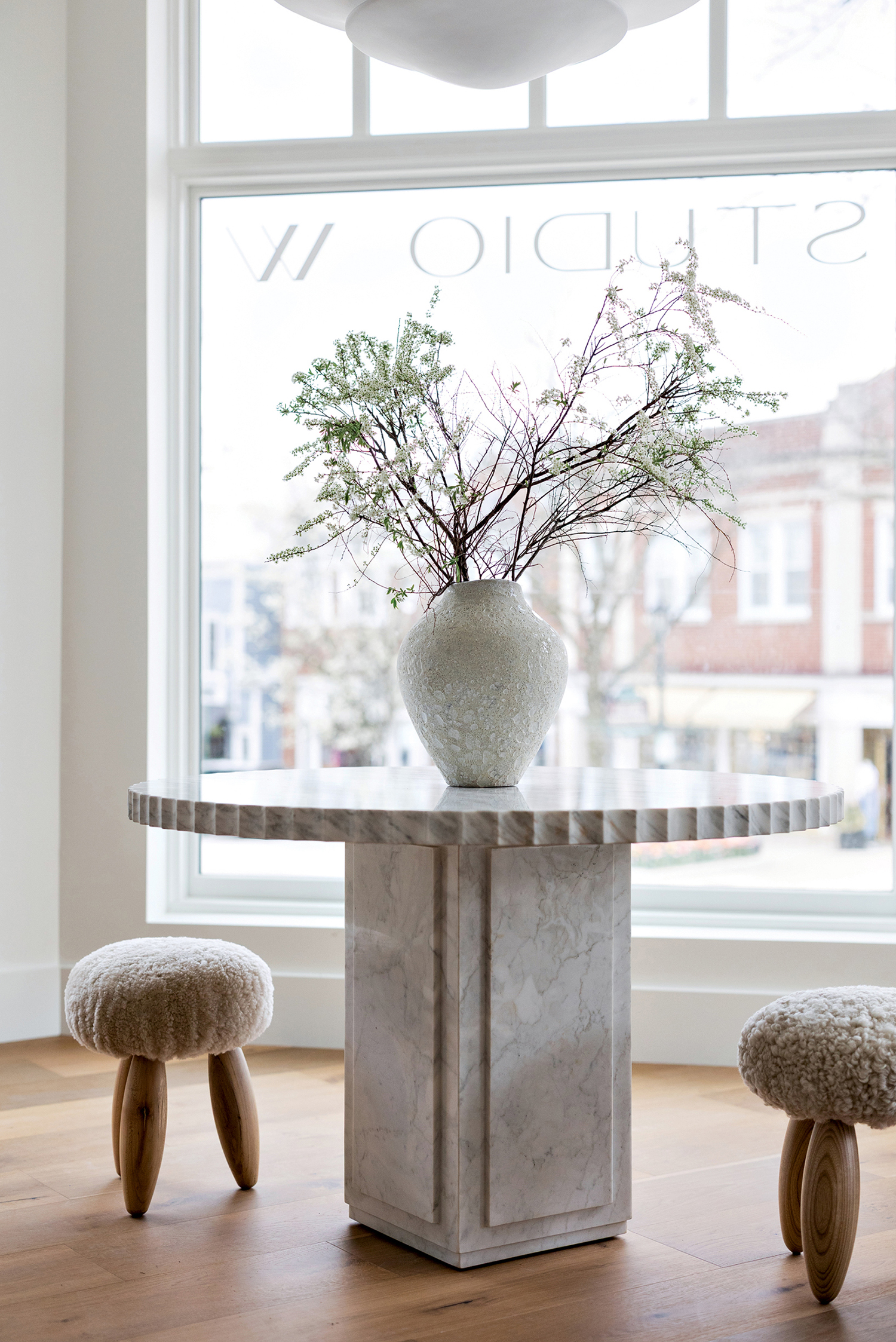 table surrounded by ottomans in Studio W Interiors' new Chicago shop