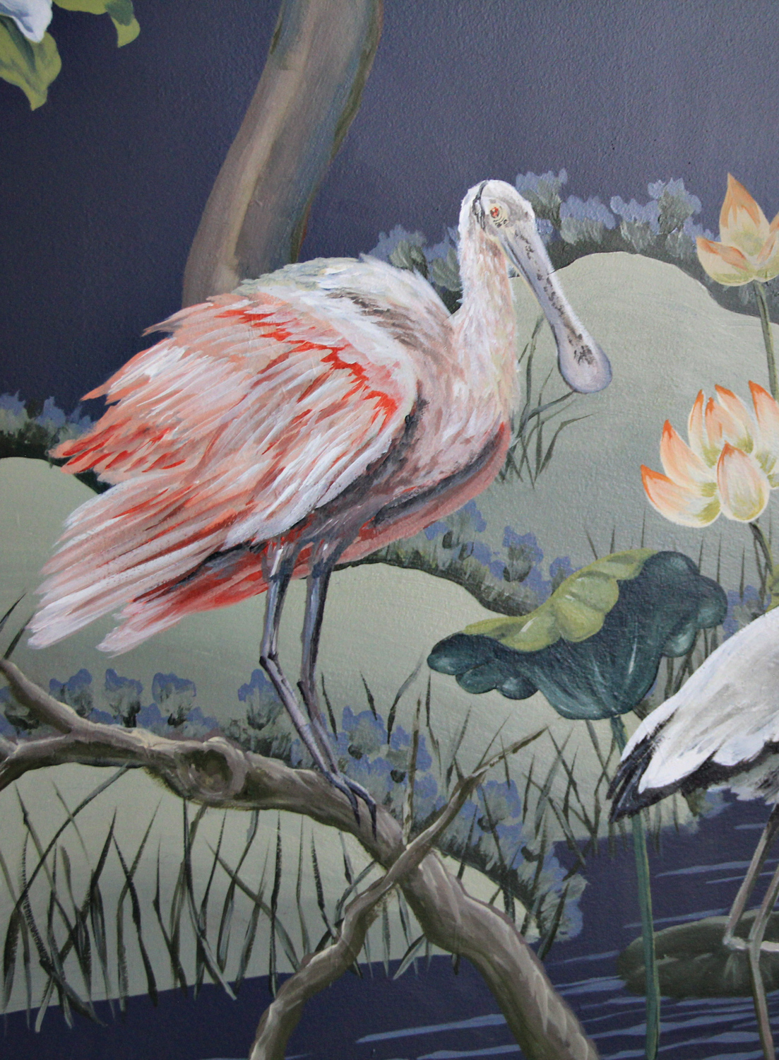 Hand-painted wall mural of a pink-and-white bird in a marsh-like environment