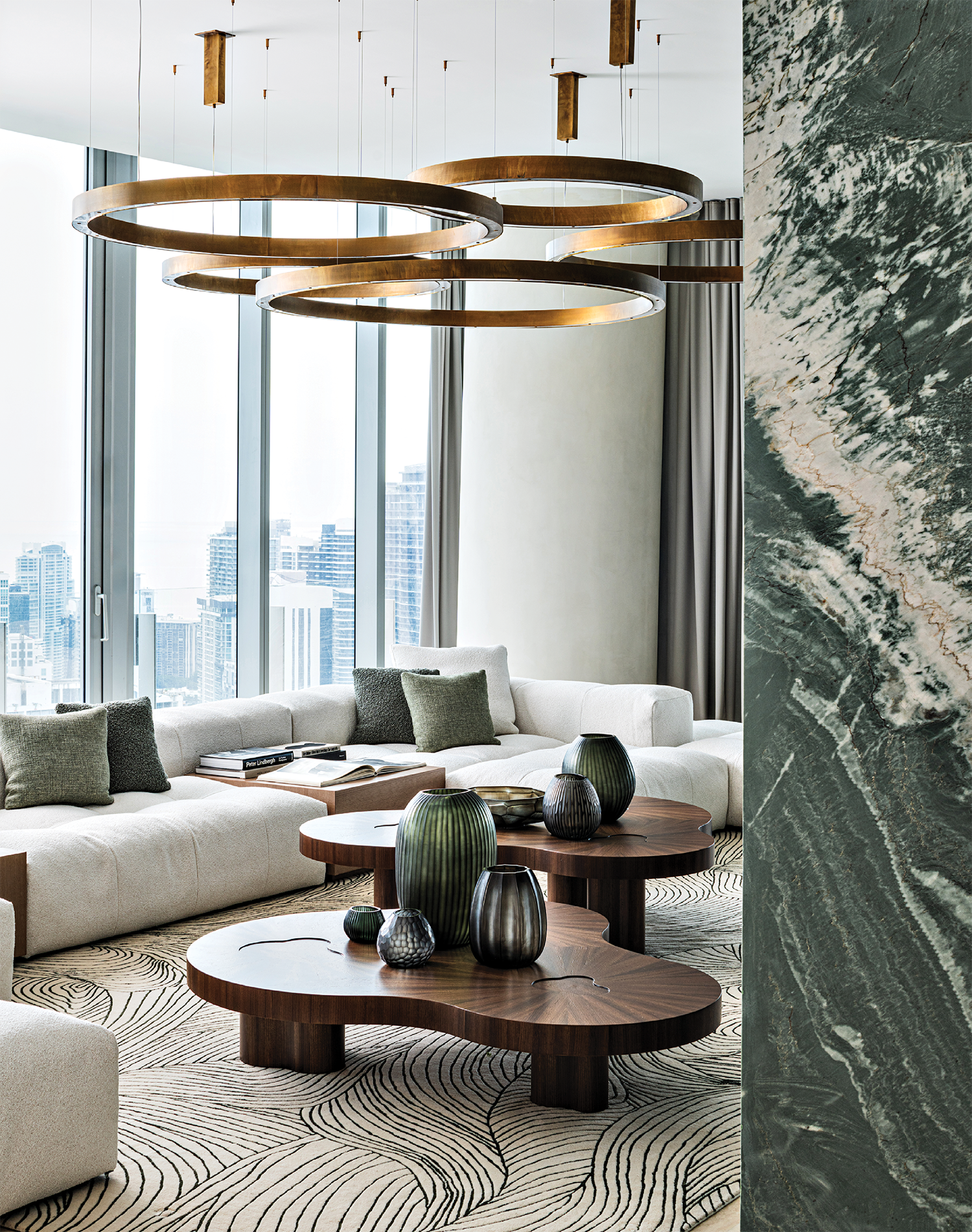 modern family room with a green marble wall and a pair of nesting tables