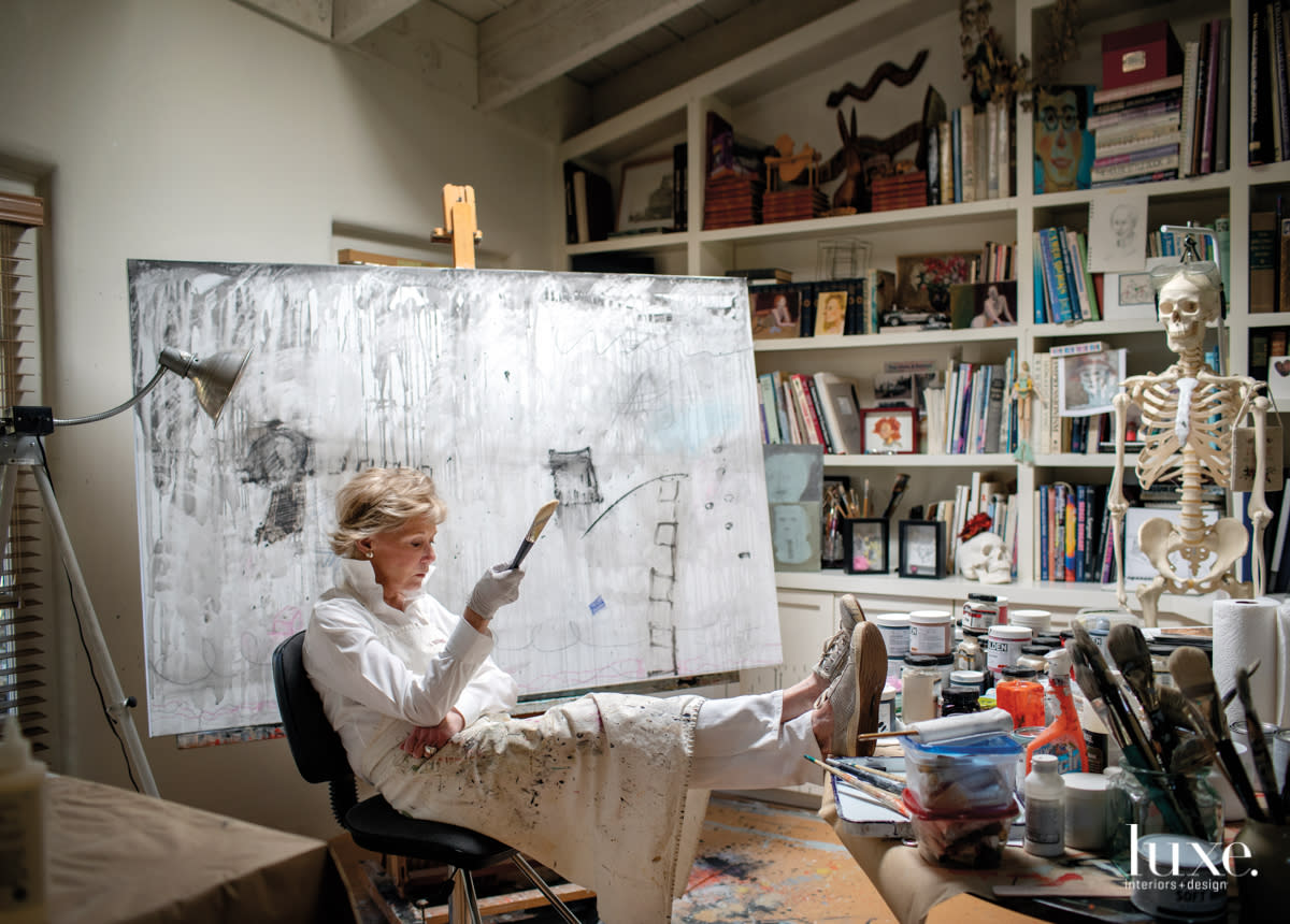 Pratt sits before a canvas in progress in her book- and art-filled studio.