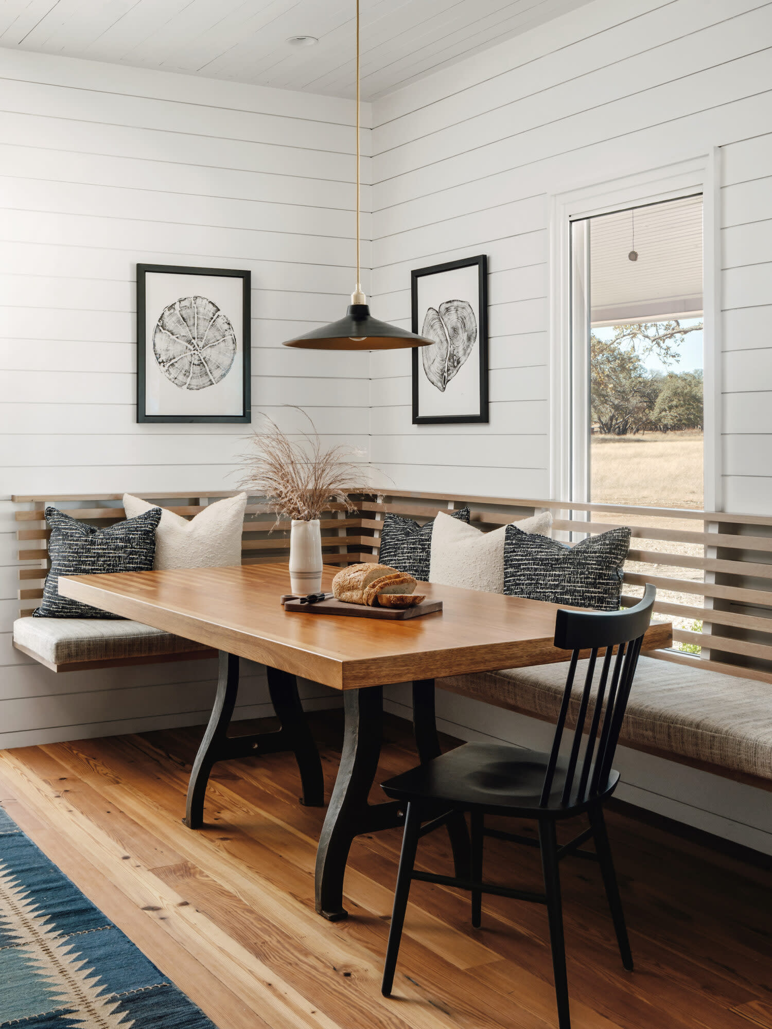 Kitchen nook with wood table and pendant light.