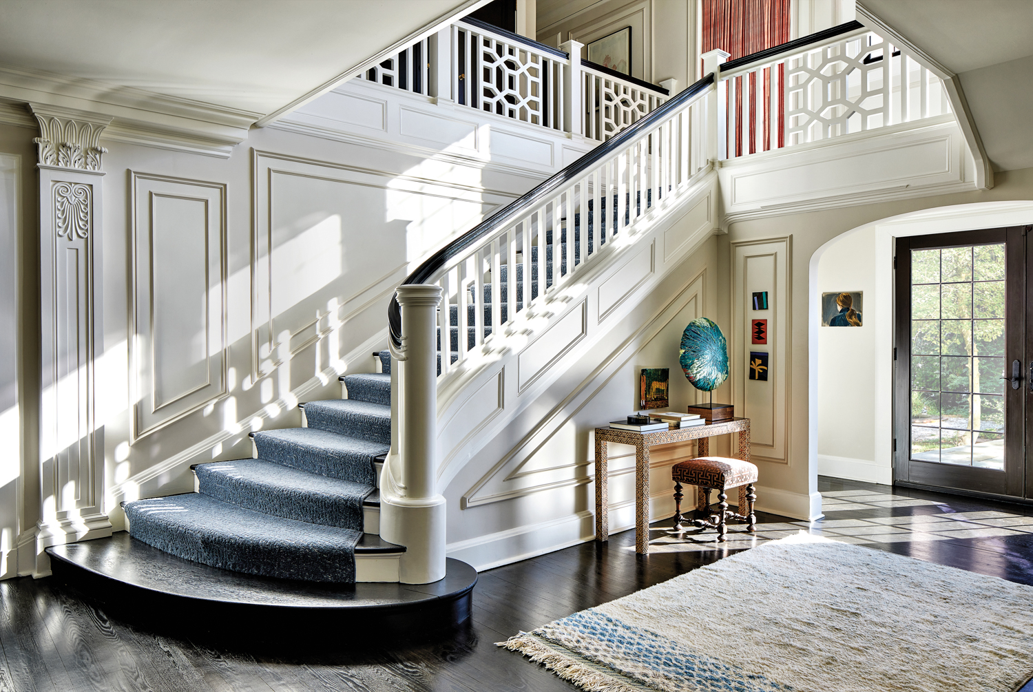 crisp white entry with white staircase and millwork in home by Teresa Manns