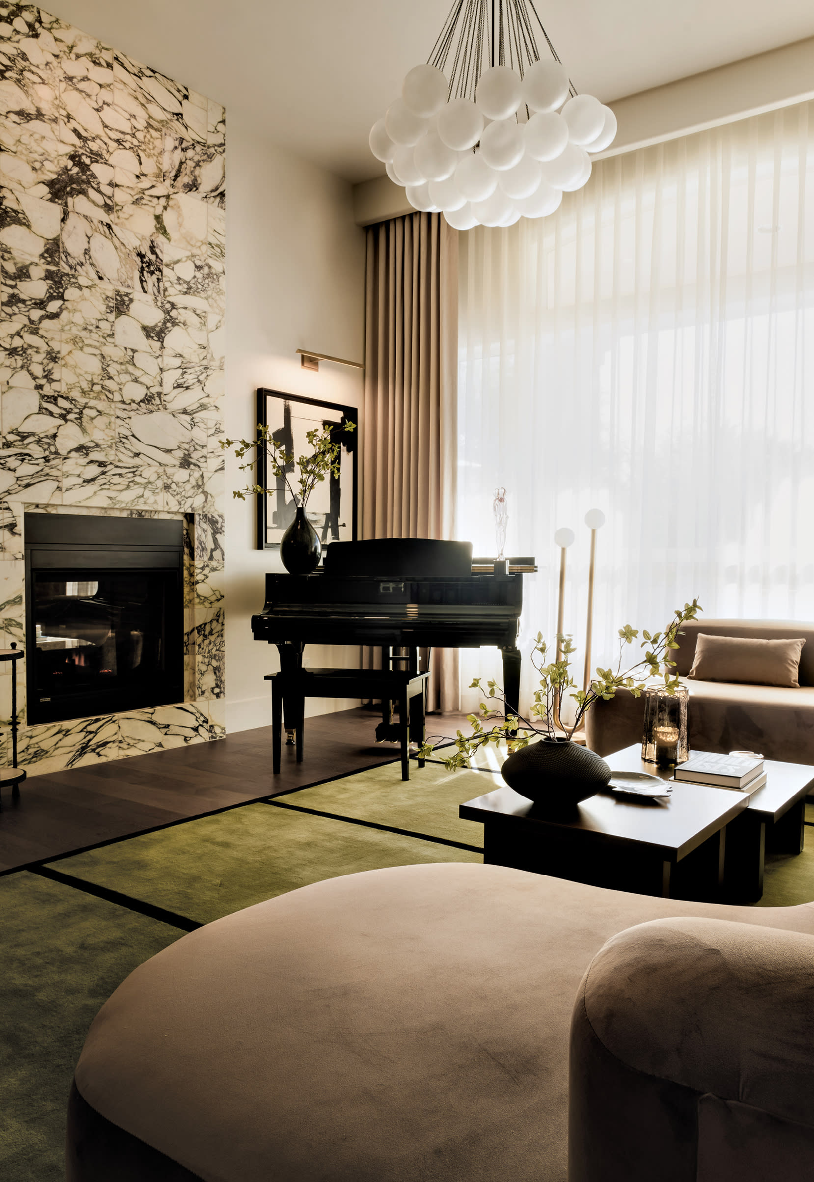 contemporary living room with a green rug and a bubble chandelier