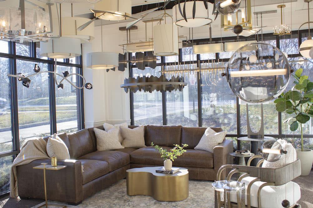 Showroom featuring a leather sectional, coffee table, and a variety of lighting options.