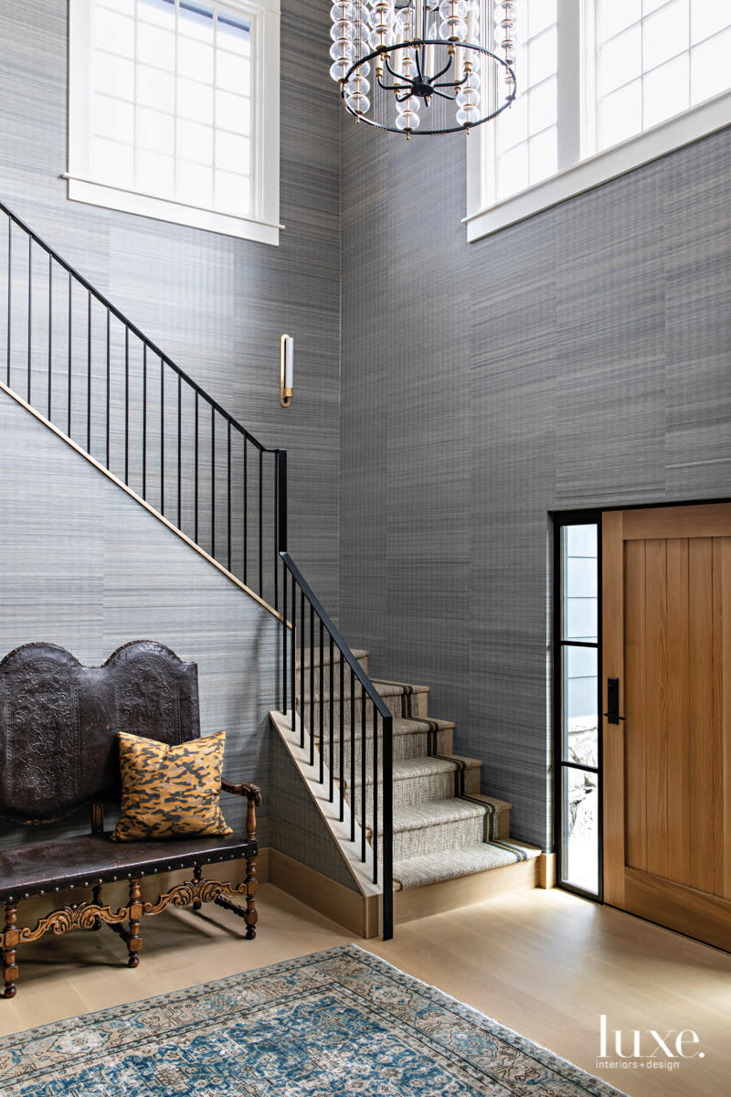 Double-height entry with grasscloth wallcovering.