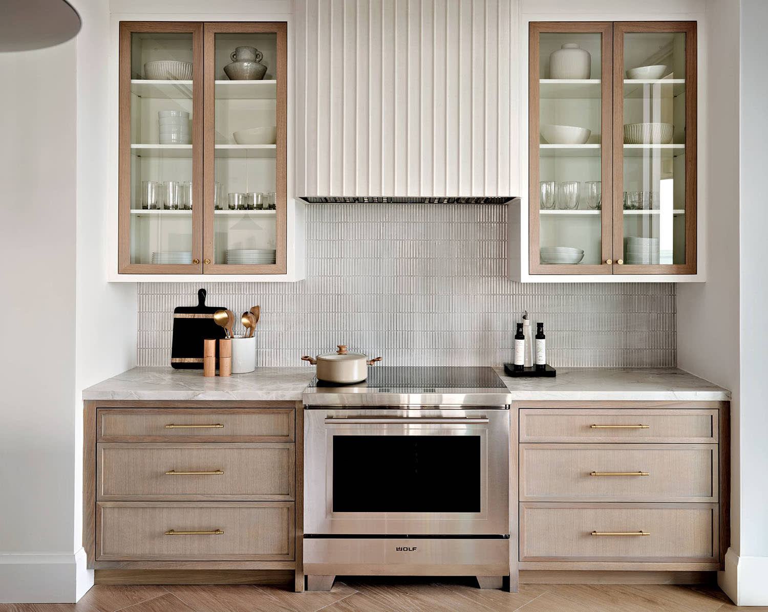 glass-covered shelving next to a plaster hood in a contemporary kitchen