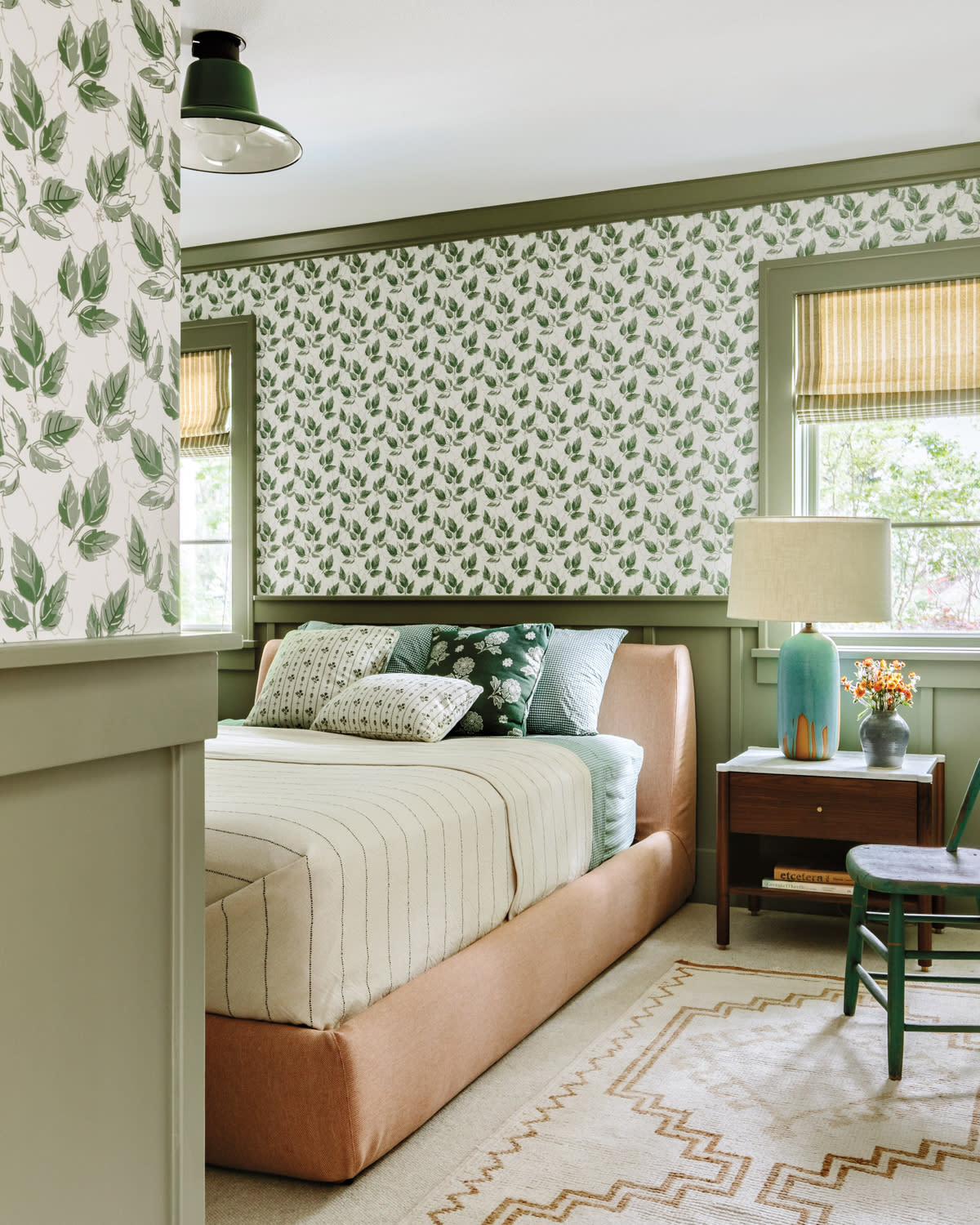 cozy guest room with white and green wallpaper and green batten board