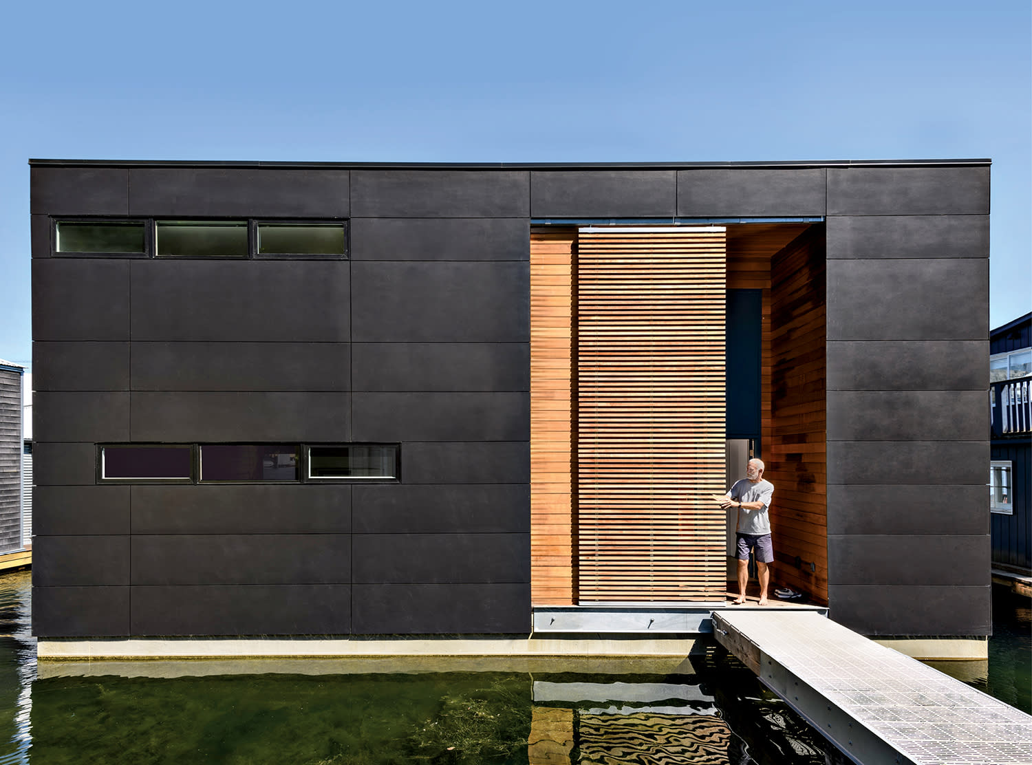 a black houseboat with wood screens that can open and close