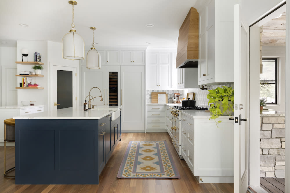 Wood range hood and navy island provide balance and warmth in this classic kitchen. 