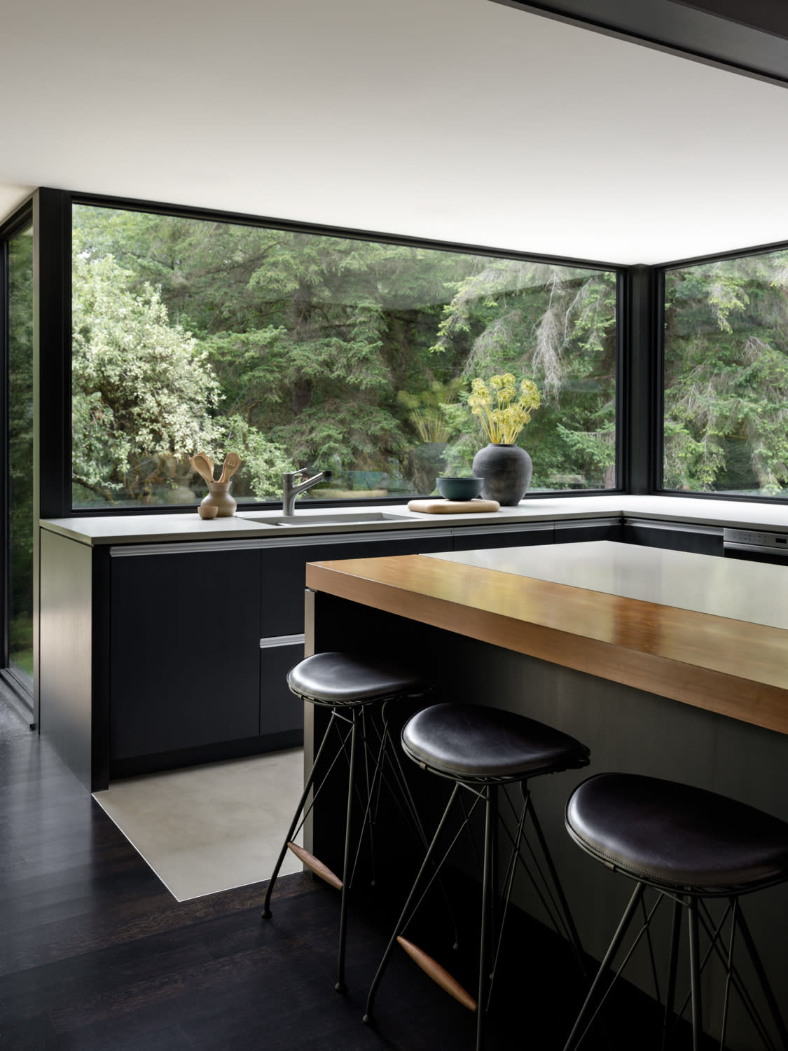 modern, sleek kitchen with black stools around an island
