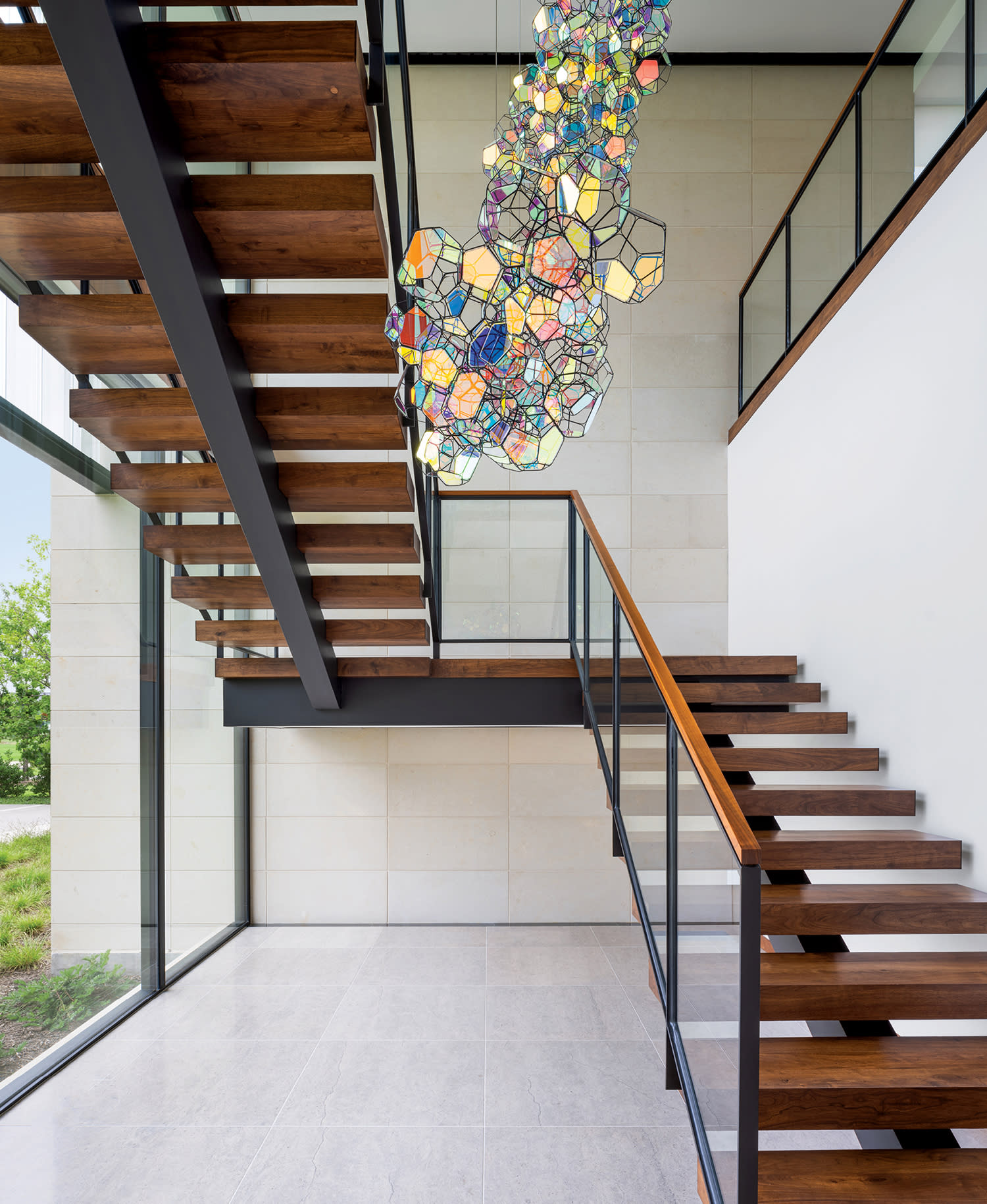 an iridescent sculpture hangs within a staircase at a modern Dallas home by Bodron Fruit