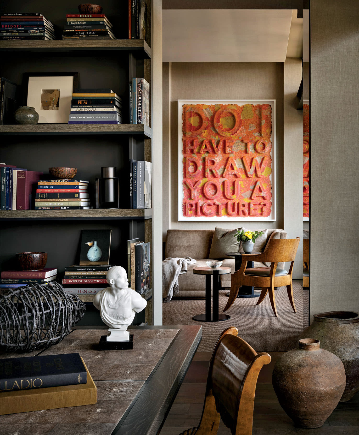 Cozy interior with a bookshelf filled with books and decor, leading to a seating area