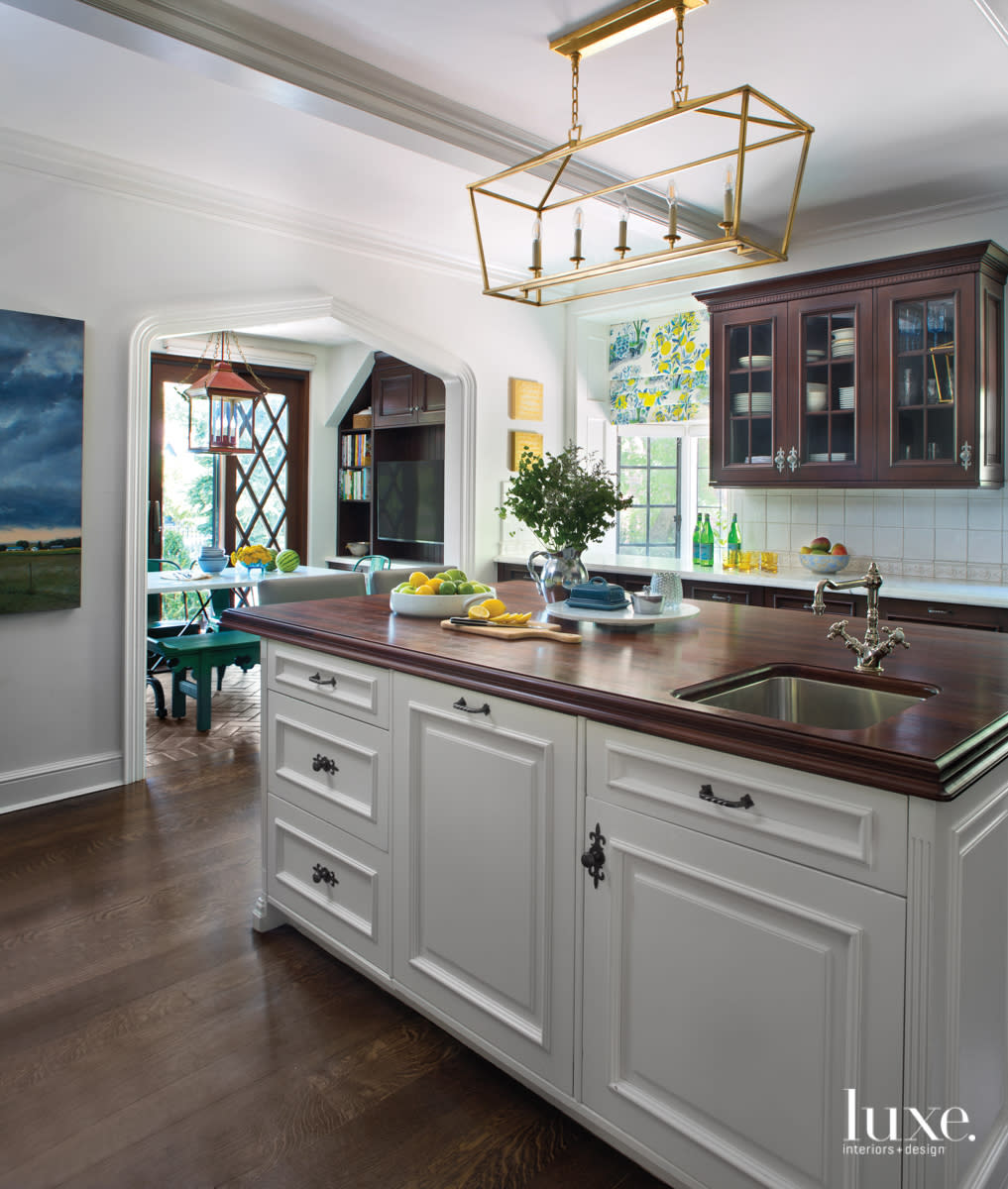 The kitchen has white cabinets and a gold-toned light fixture.