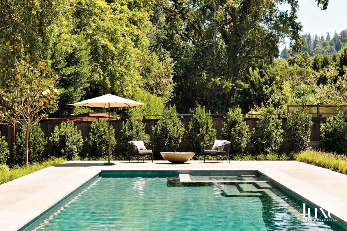 A pool is set in a wooded landscape.