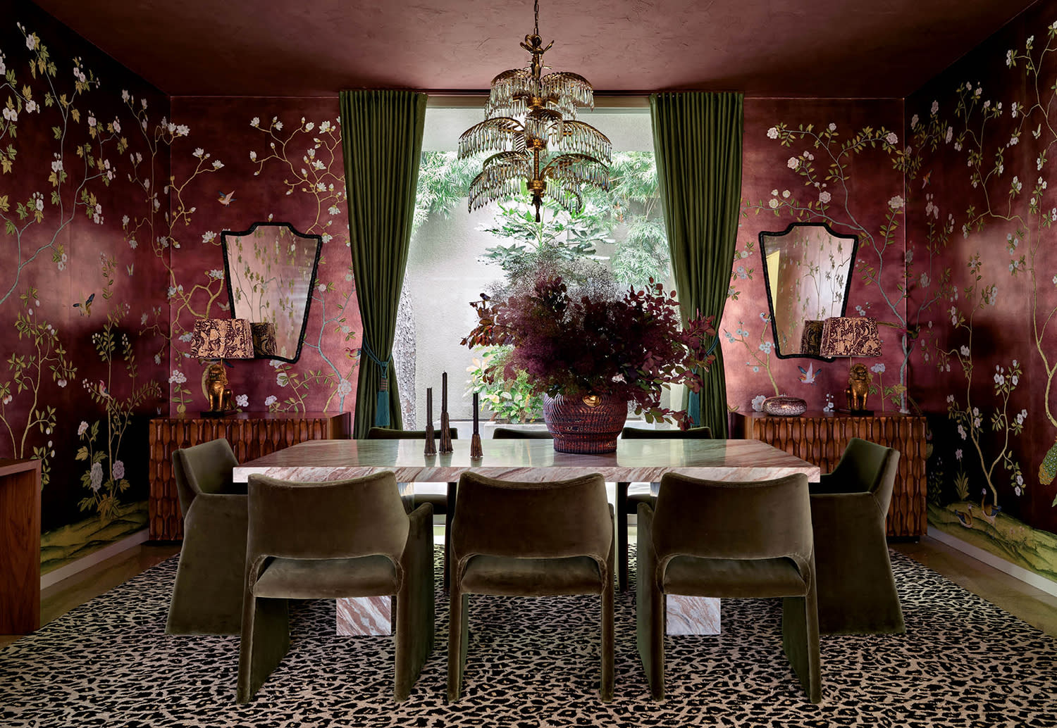 midcentury-style dining room with a red floral wallcovering, pink-marble table and velvet chairs