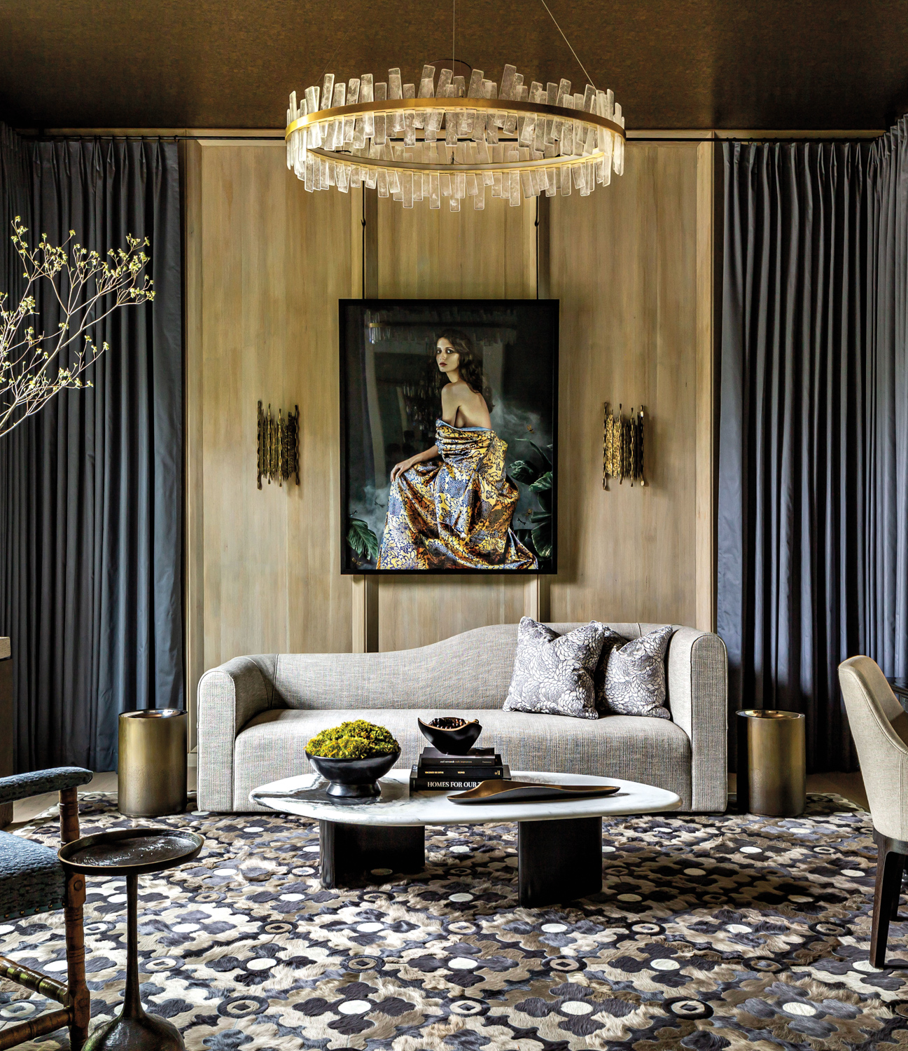 Whitney Ray moody living room with floor-to-ceiling blue curtains flanking artwork of a woman’s portrait