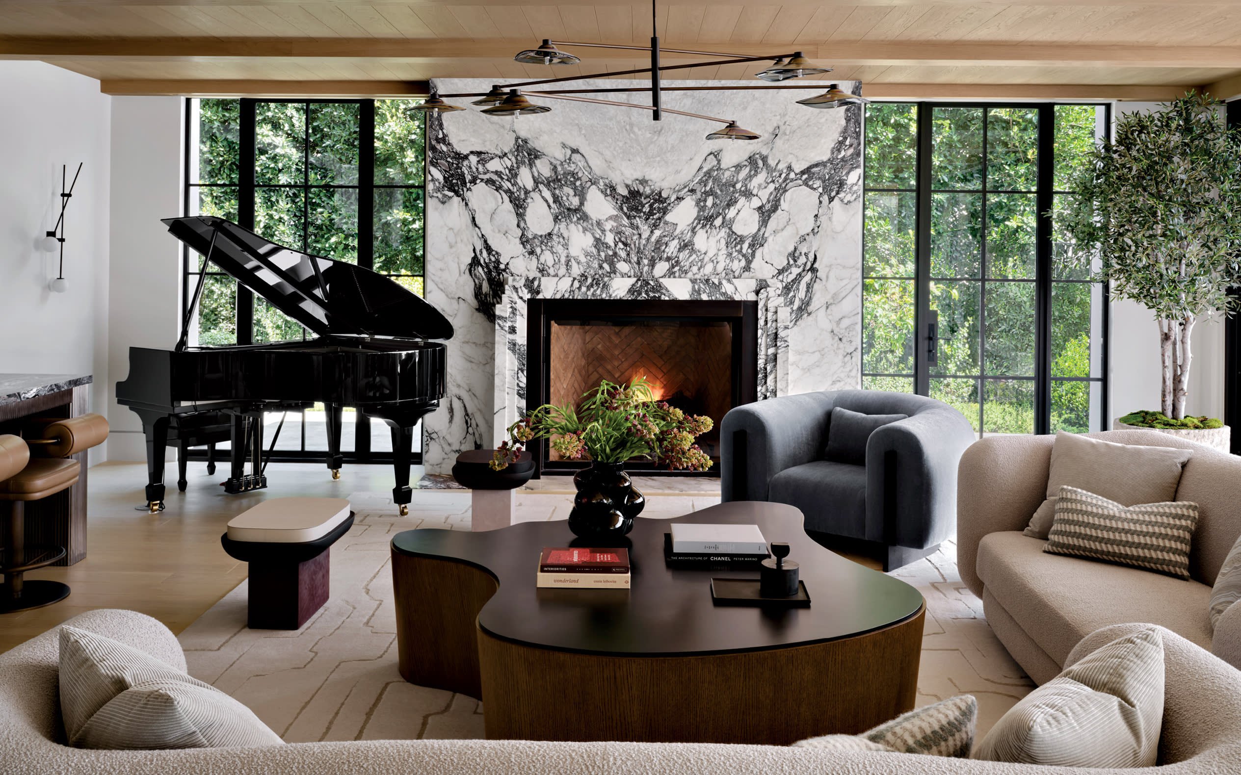 contemporary great room with a piano, organically-shaped coffee table and beige sofas