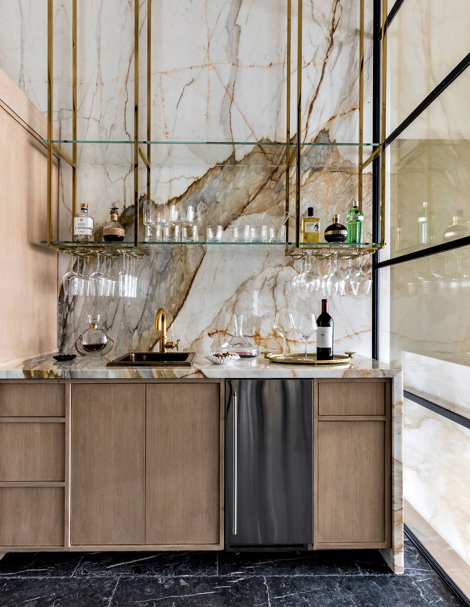 wine room with marble walls and a white oak vanity