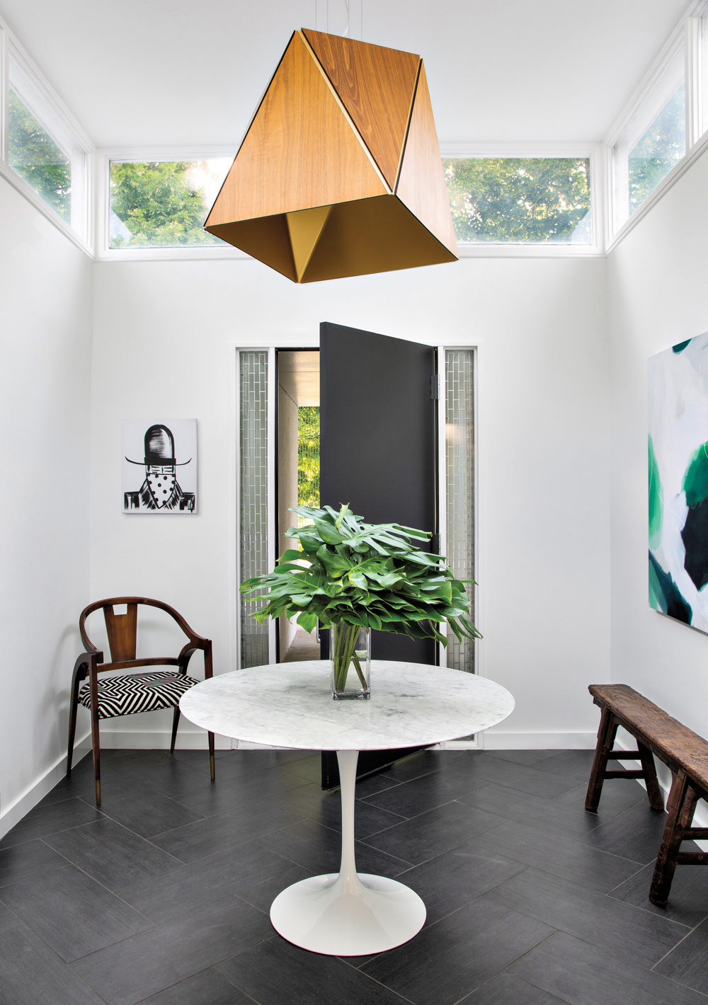 entryway with clerestory windows and a tulip table at center, beneath a contemporary wooden pendant