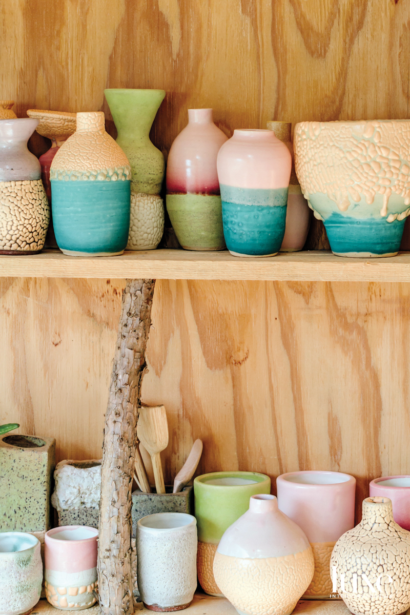 A selection of colorful ceramic vessels on shelves