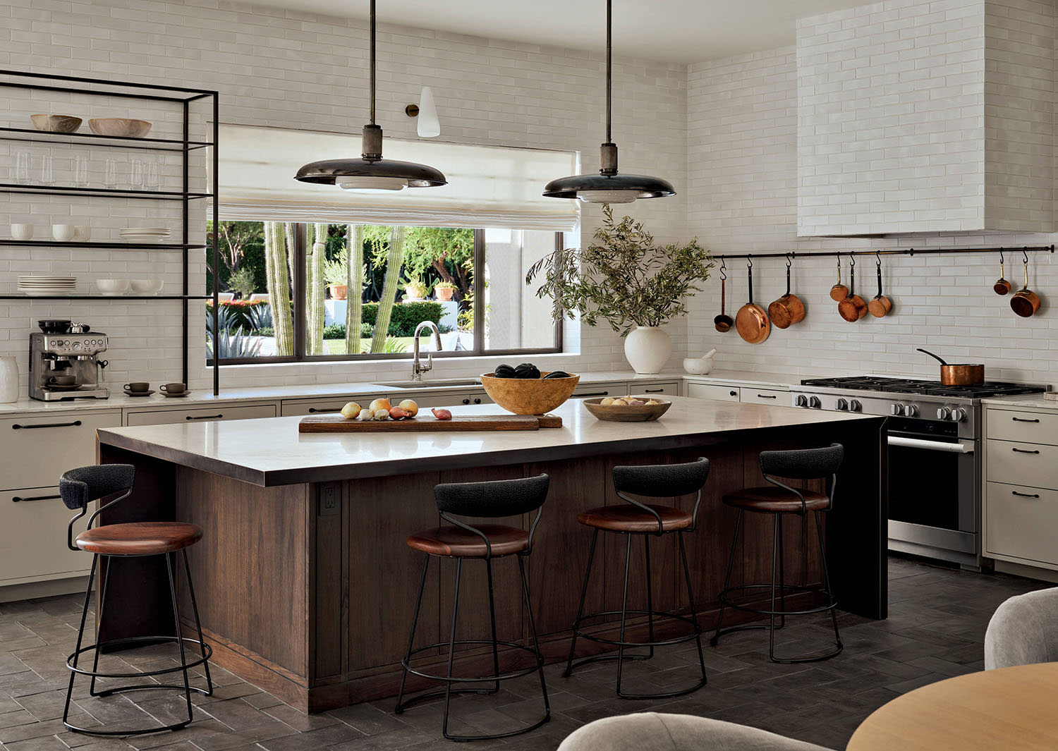 A kitchen with white cabinets and matching tile, with a wood center island and counter stools.