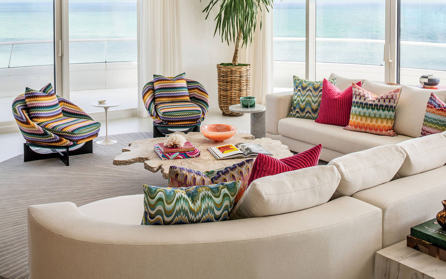 living area of a South Florida condo with a white sectional, striped armchairs and colorful pillows