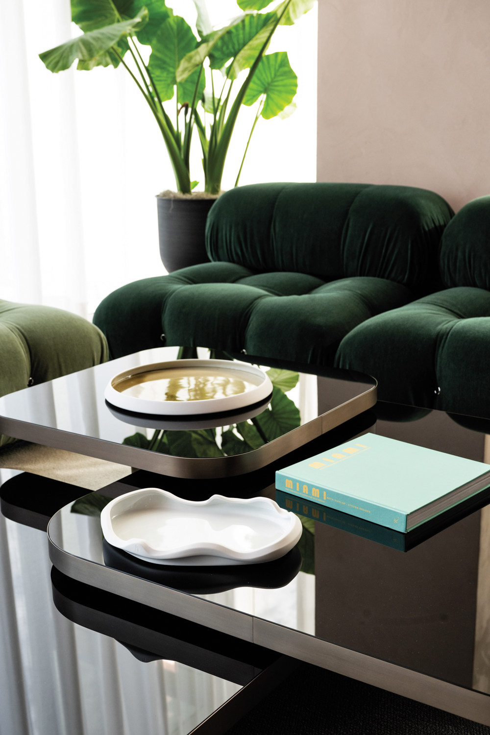 three-tier coffee table with a green velvet sofa