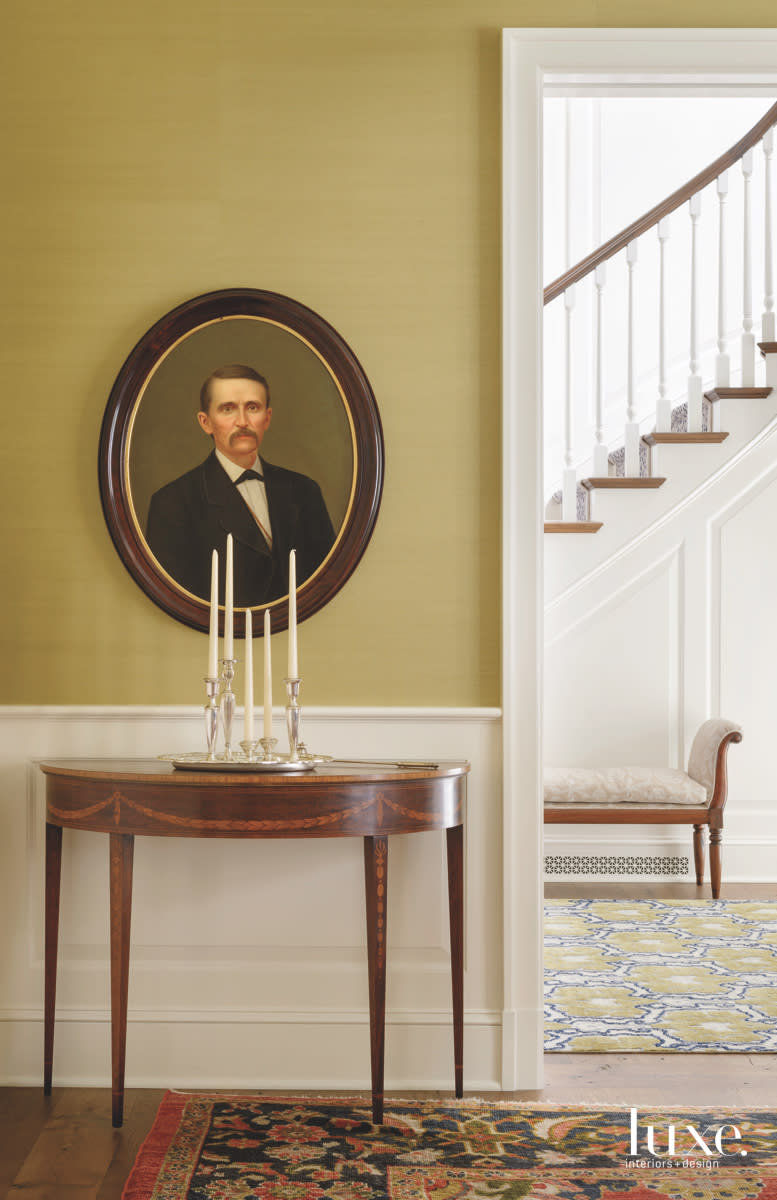 traditional dining room hall with a yellow wall and a portrait by Massucco Warner Miller