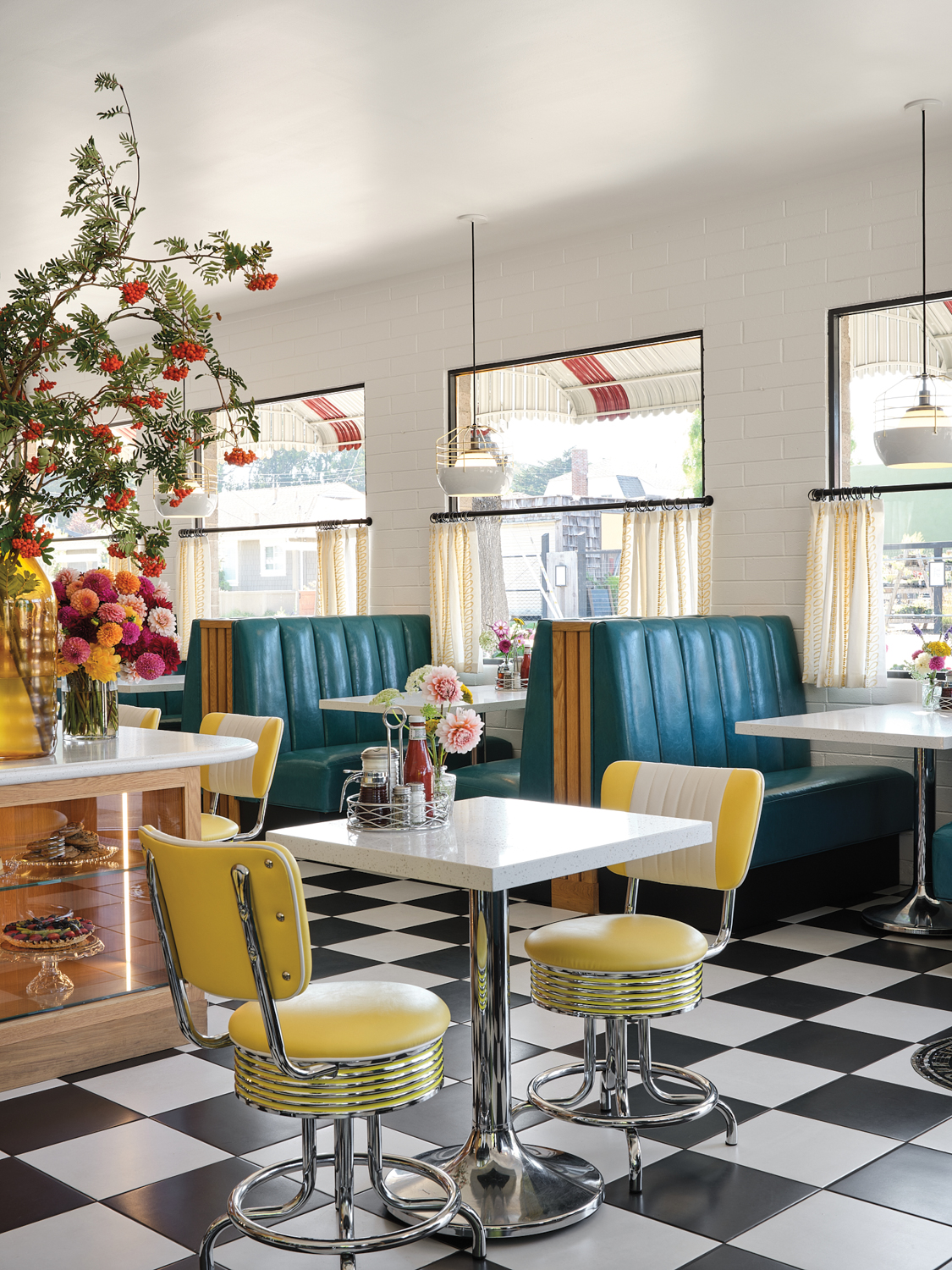 Diner with black-and-white floors, yellow chairs and blue booths