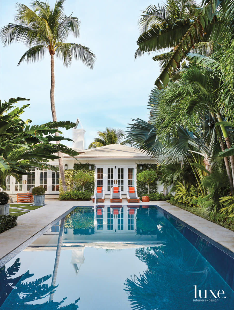 image of the pool and grey, white and orange lounge chairs