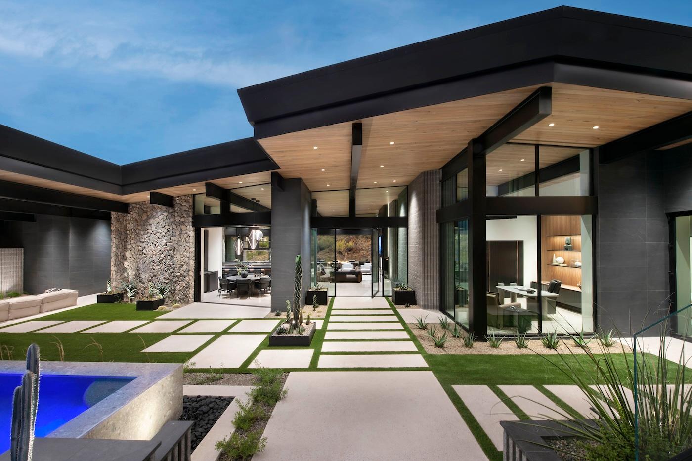 Modern home with expansive glass walls, geometric lines, and a courtyard featuring a pool. The space is sleek, open, and exudes luxury.