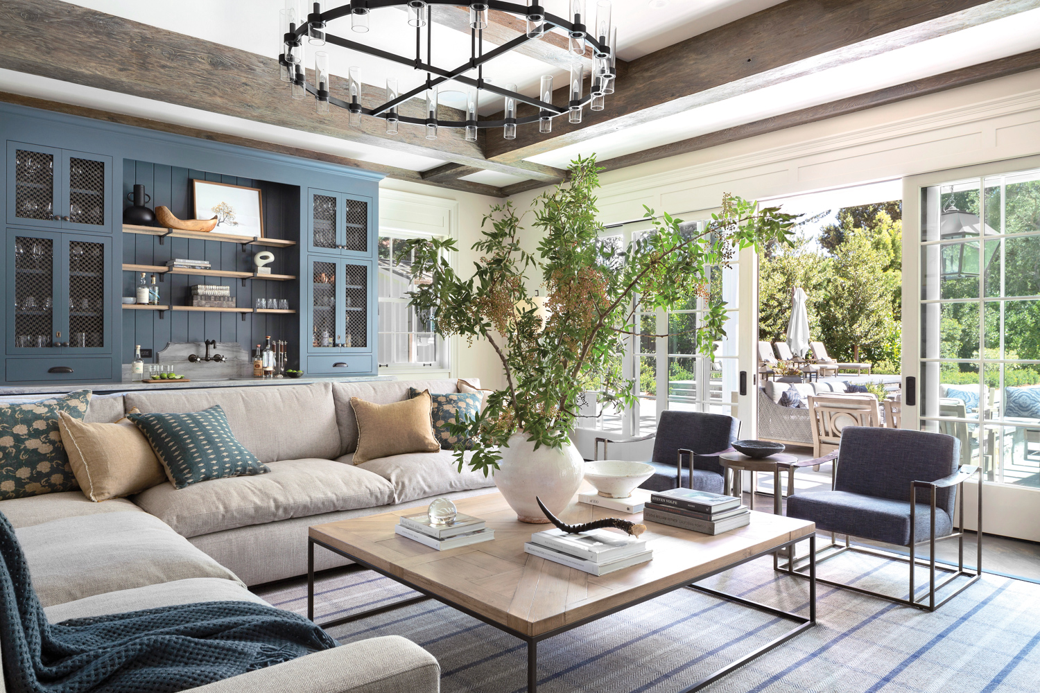 Living room with cream-colored sectional in front of blue cabinetry 