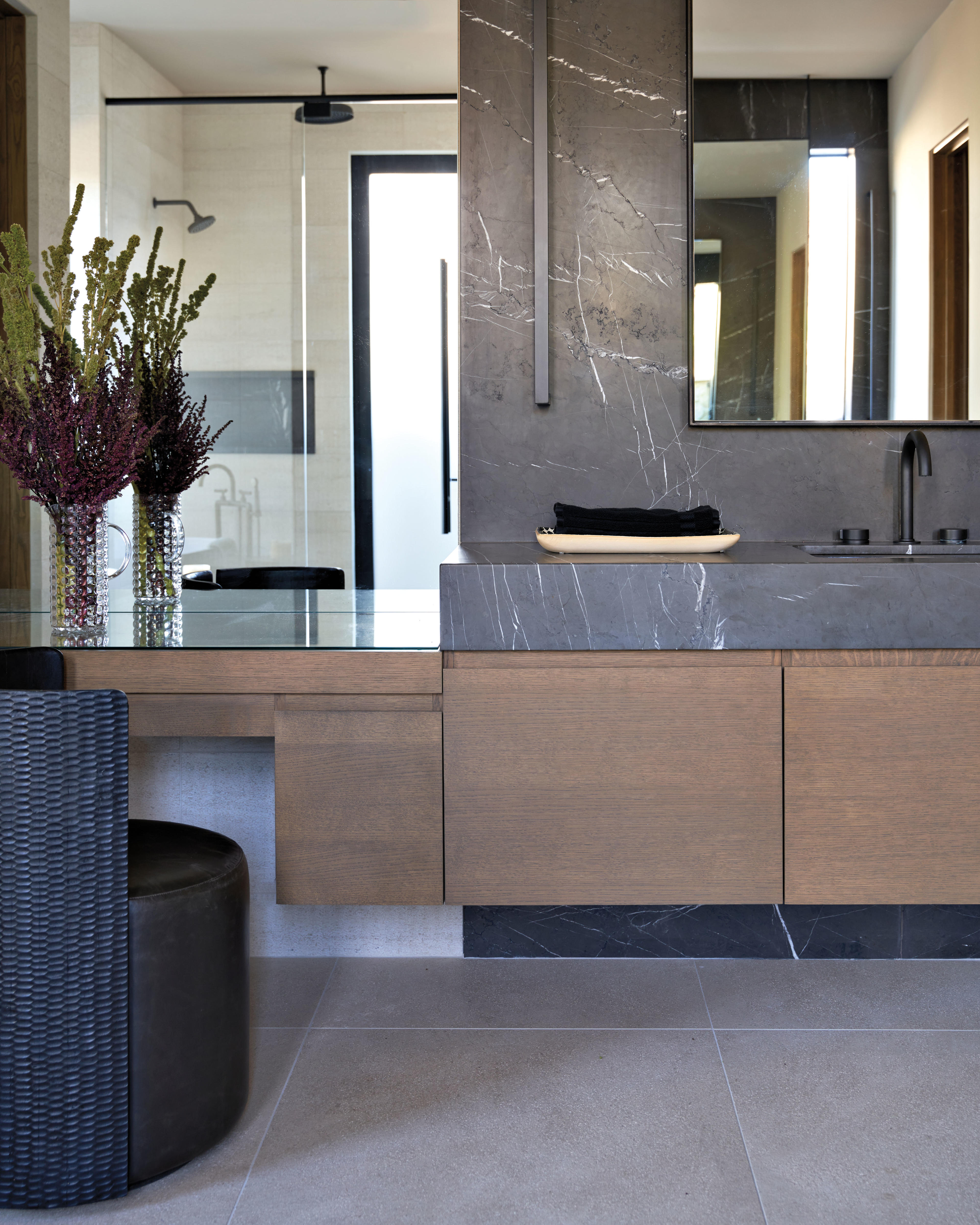 white oak cabinetry topped by graphite marble in a primary bathroom