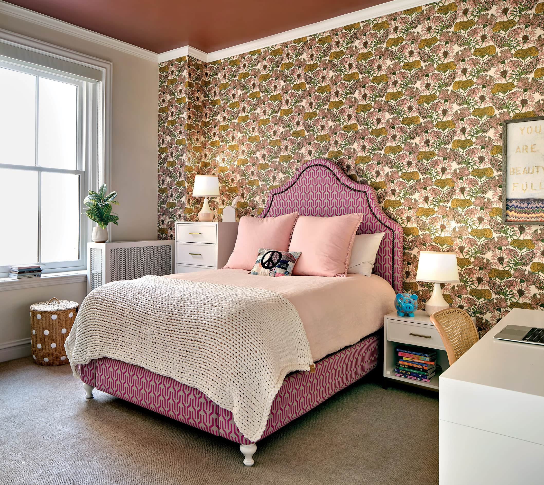 floral wallpaper lines a wall in this girly vintage bedroom with a Serena and Lily bed