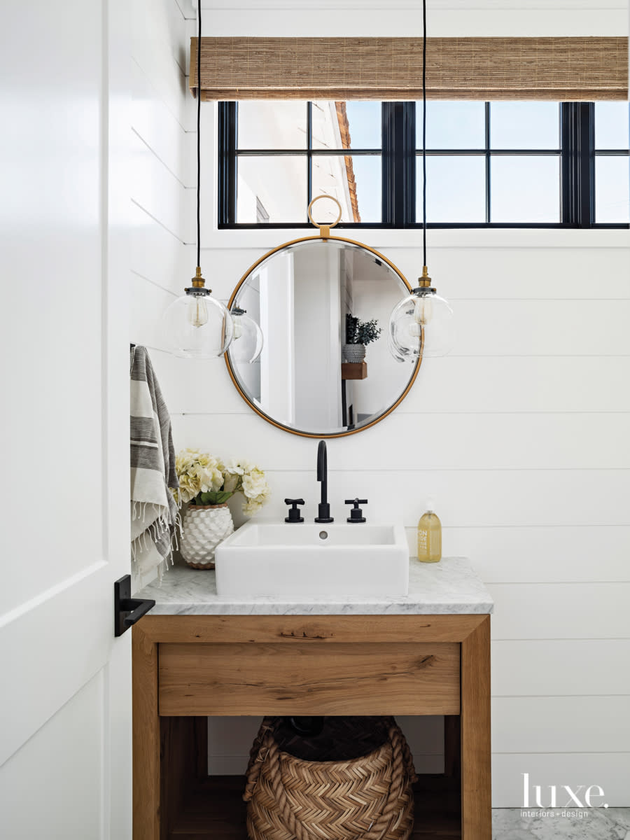 powder room with nautical theme, round mirror and low hanging light fixtures