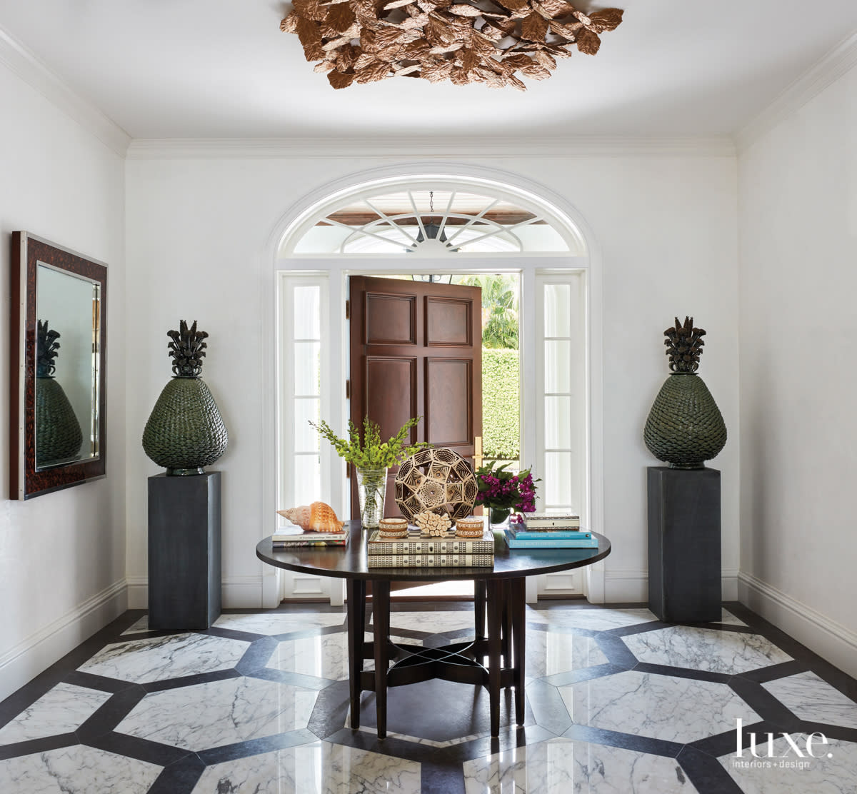front door with geometric marble flooring, a center table and wooden door