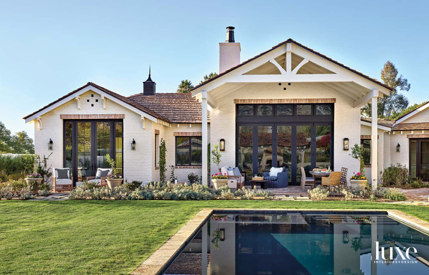 A white brick home with a pool in the backyard.