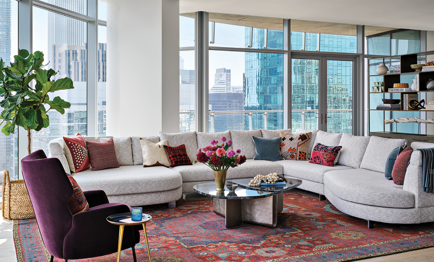 penthouse living room with an off-white sectional, red rug and purple armchair