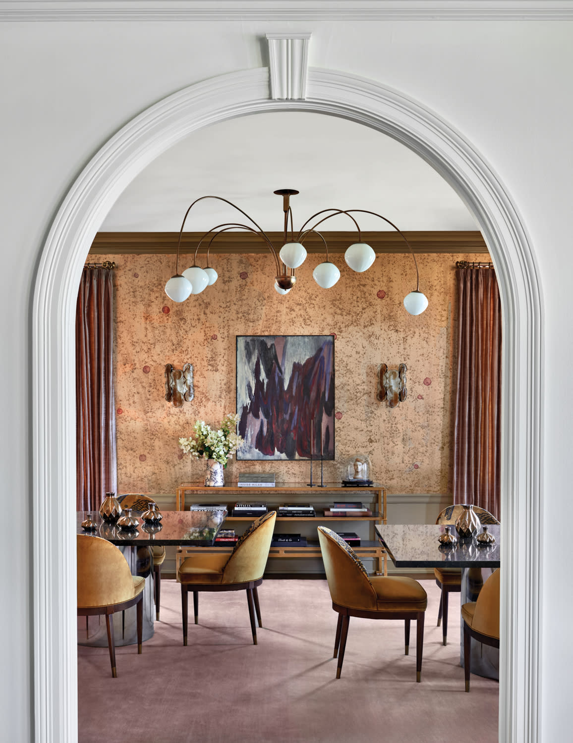 arched doorway leading into a traditional dining room with a moody color palette