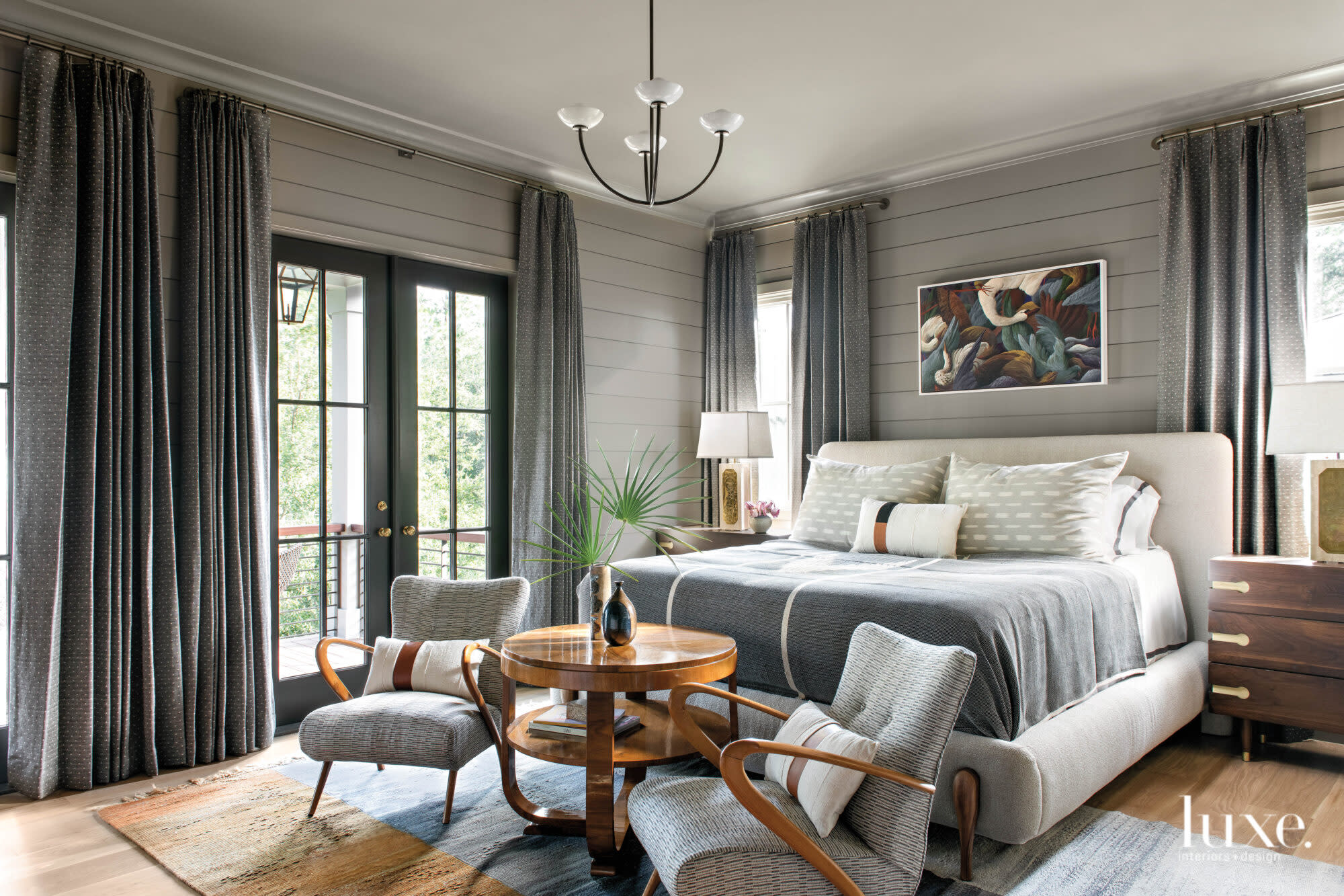 Gray bedroom with French doors to porch, sitting area and vintage art