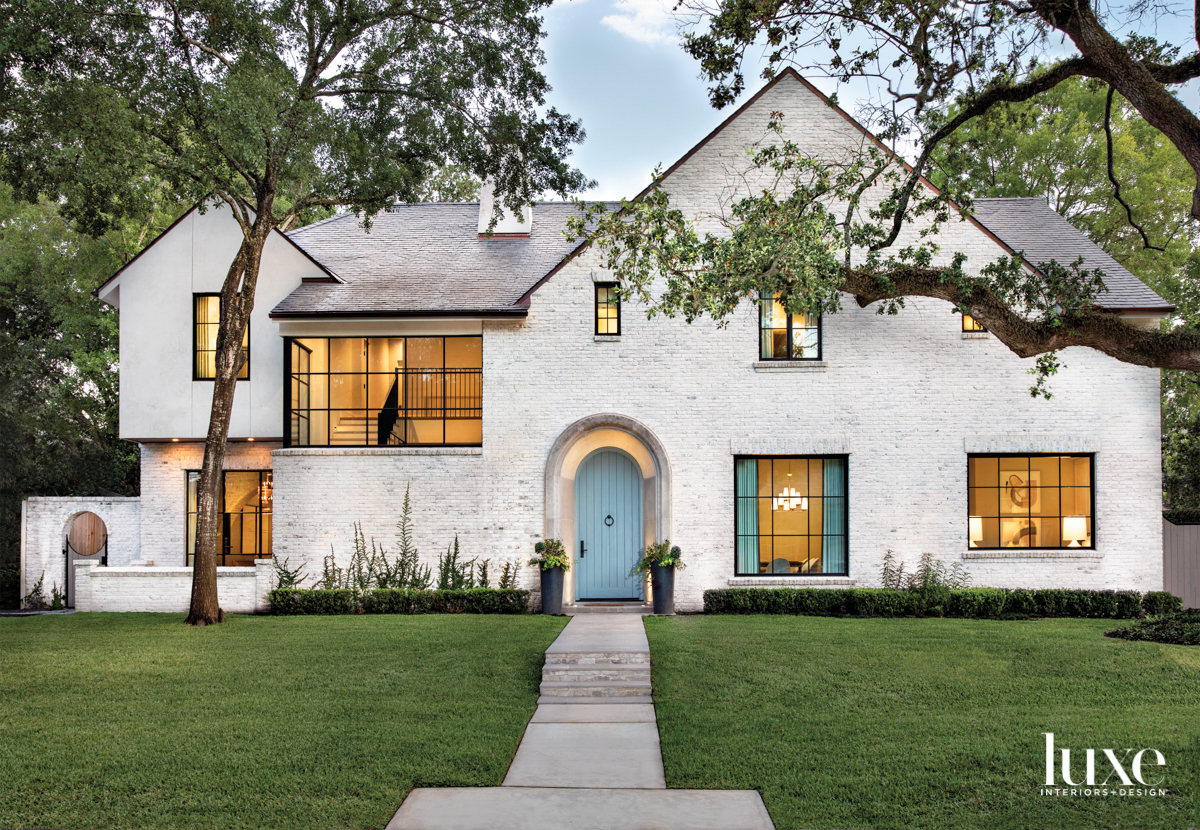 Facade of a Houston home featuring painted brick and a blue front door.