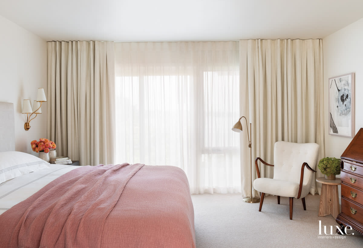 bedroom with corner chair and floor to ceiling drapery