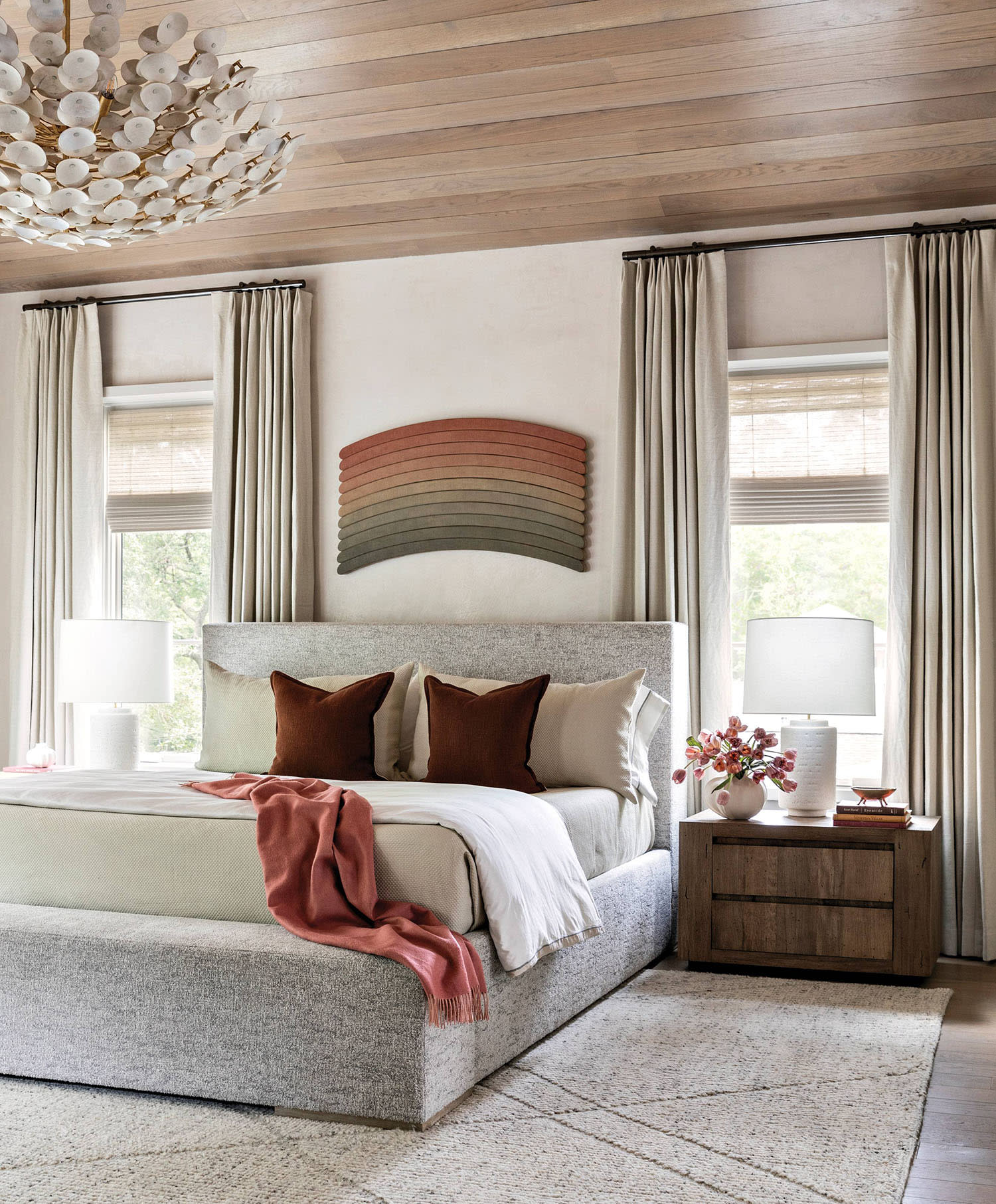 contemporary bedroom with a warm wood ceiling and gray platform bed