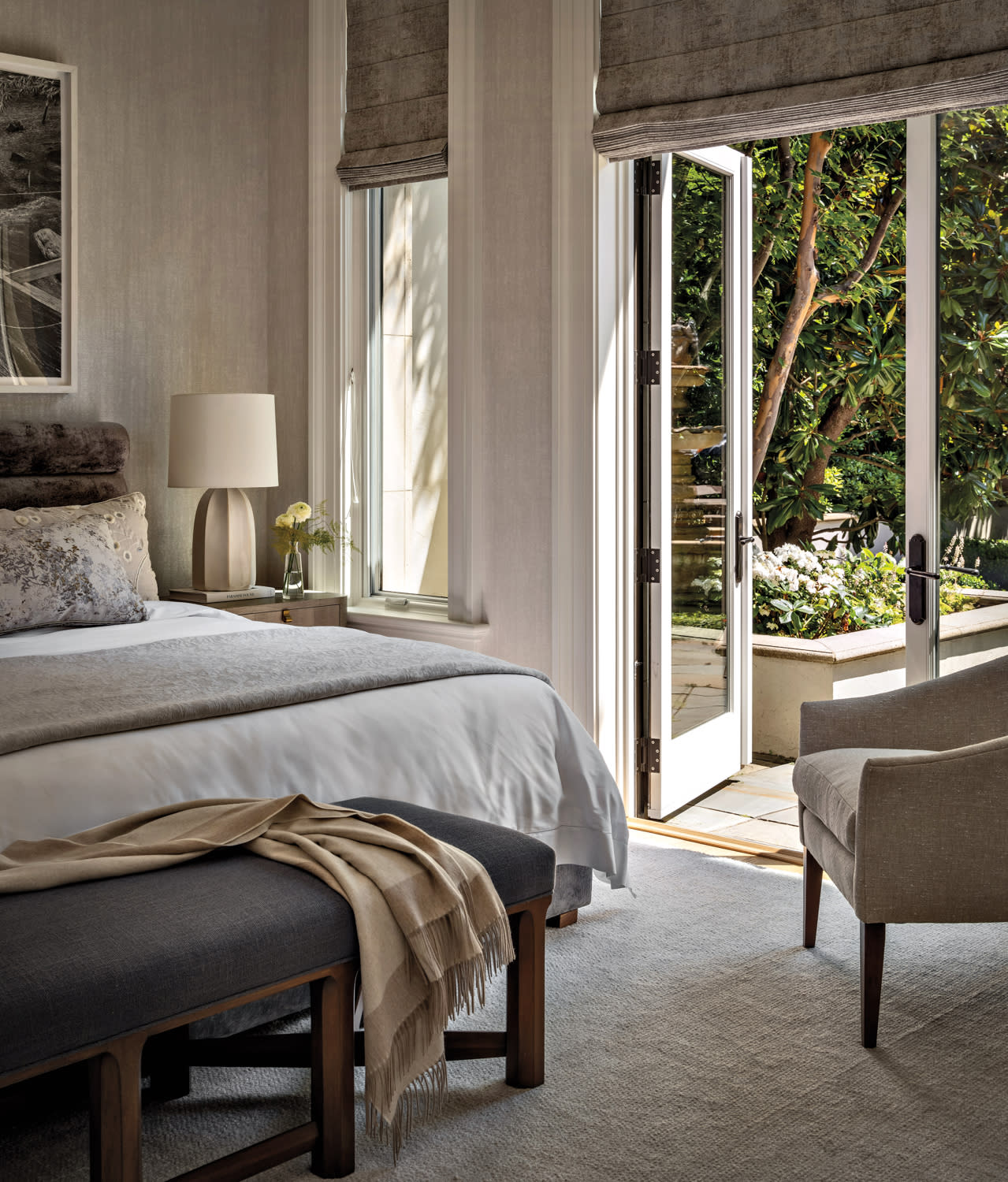 neutral, clean-lined bedroom with a door opening to a patio