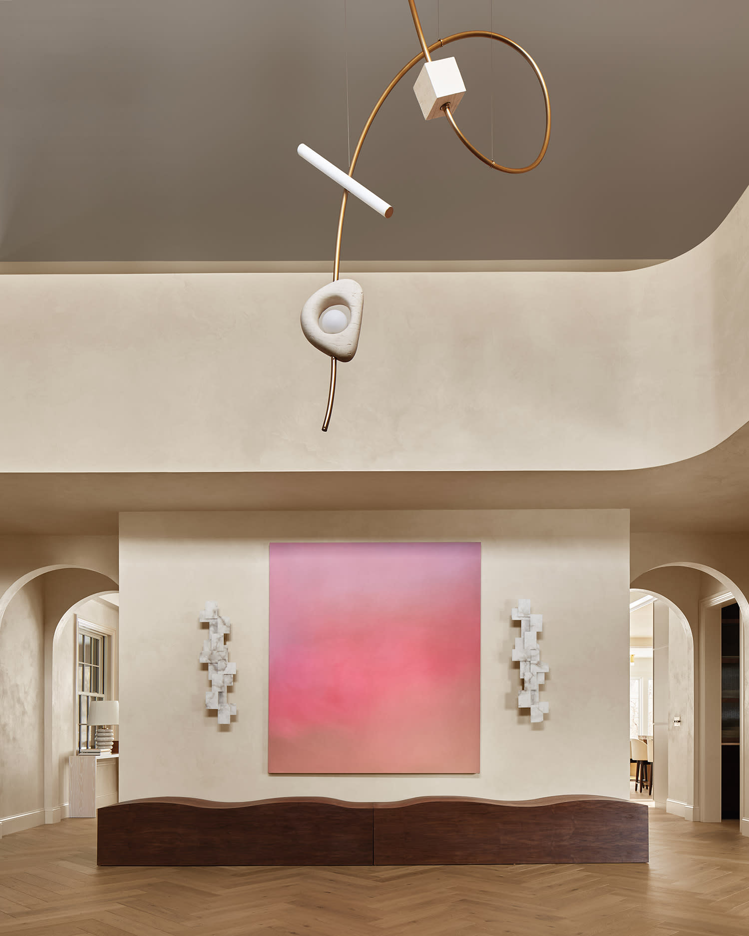 Artwork by Maximilian Rödel hangs above a bespoke walnut bench, framed by Studio Glustin sconces.