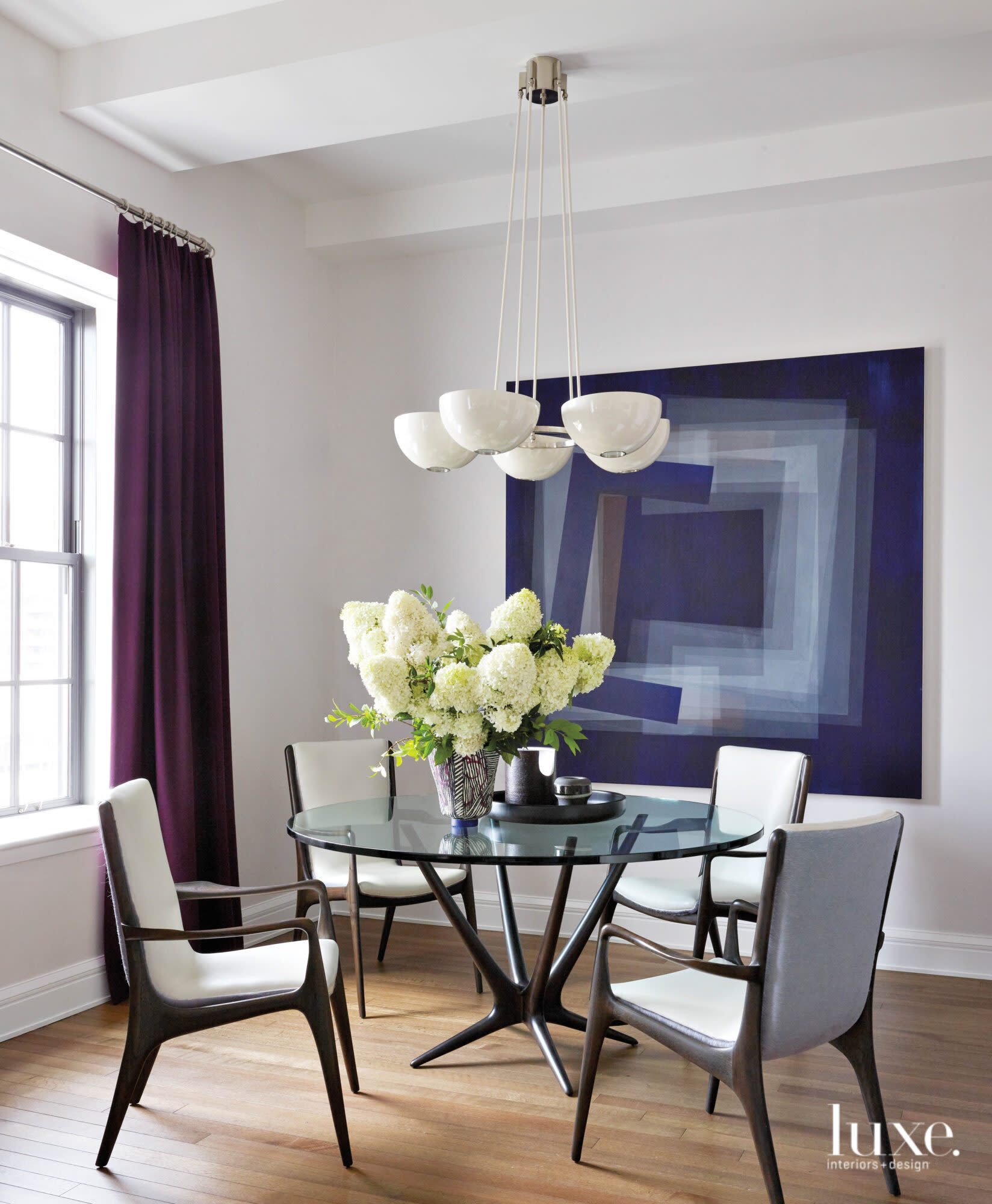 Dark blue decor surrounds a clear, round dining room table