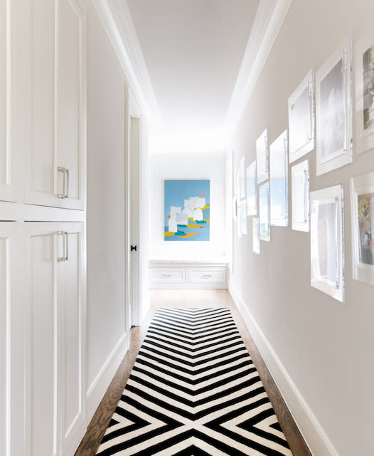 A monochrome rug adorns a hallway, adding contrast to the space with its black and white pattern.