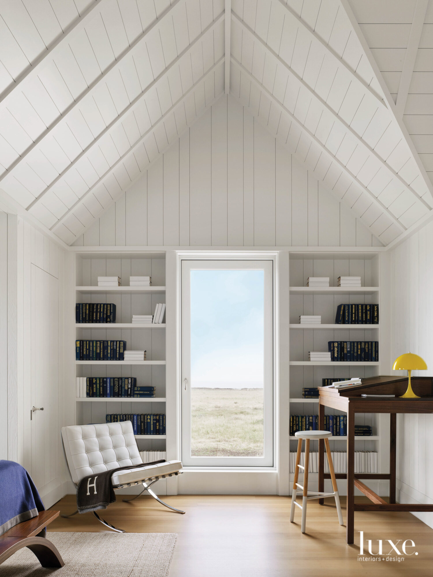 One end of the boy's room has a petite desk, white shelves and an ocean view.