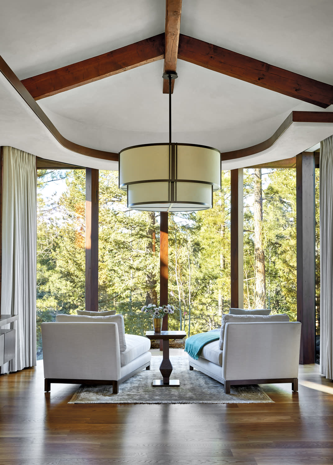 Bedroom sitting area with lounge chairs facing floor-to-ceiling windows.