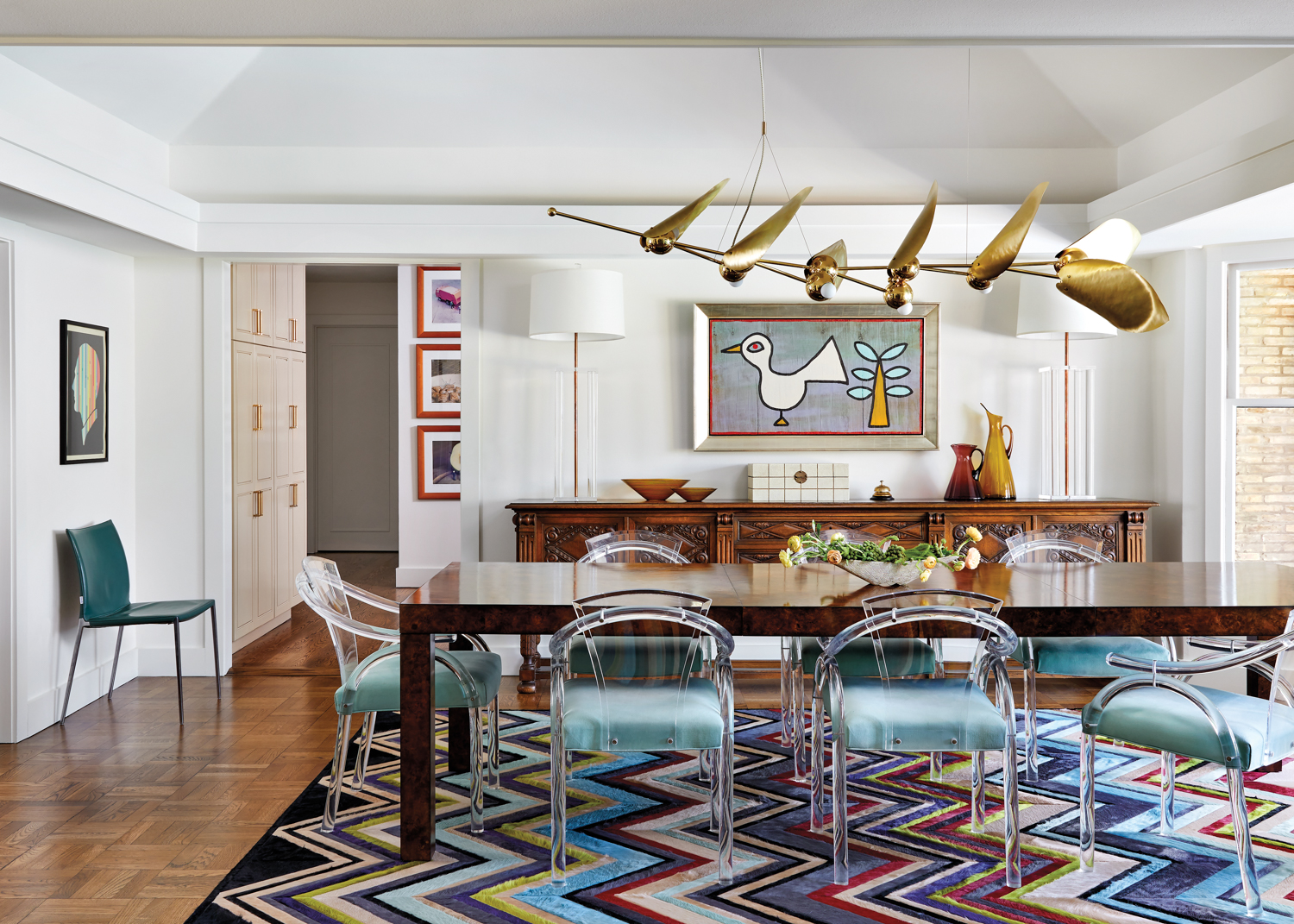 Dining room with a Missoni-inspired custom Kyle Bunting rug and cantilevered chandelier over the table and chairs